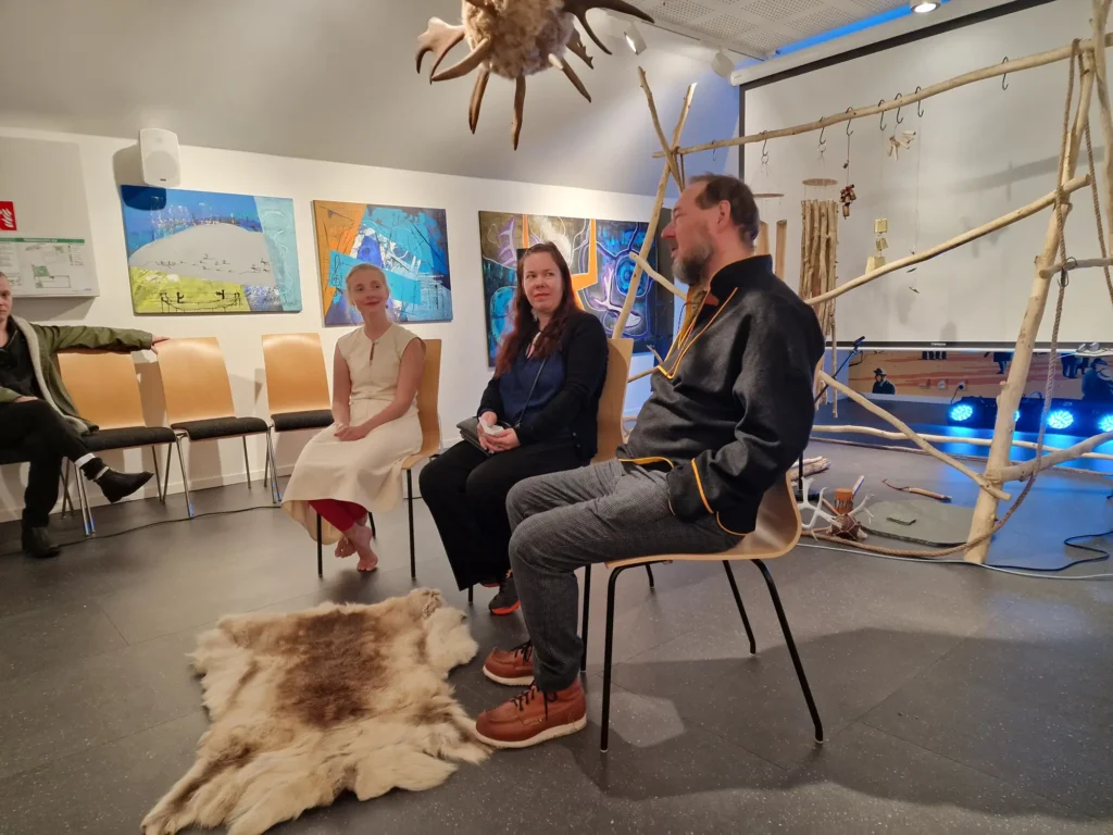 In the image you can see two artists Johan Sara Jr and Katarina Sk&aring;r Lisa, and Marija Griniuk as a moderator in the conference hall