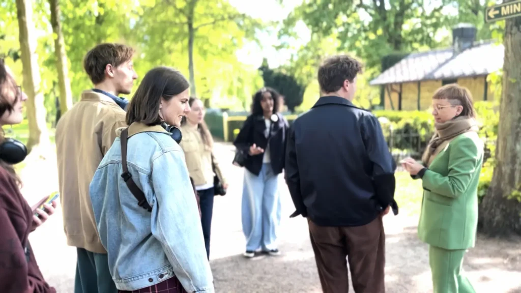 Audience members arrive at Malm&ouml; Old Cemetery for the mixed reality walk Ashes to Ashes and meet Marika Hedemyr, who is dressed in a green suit.