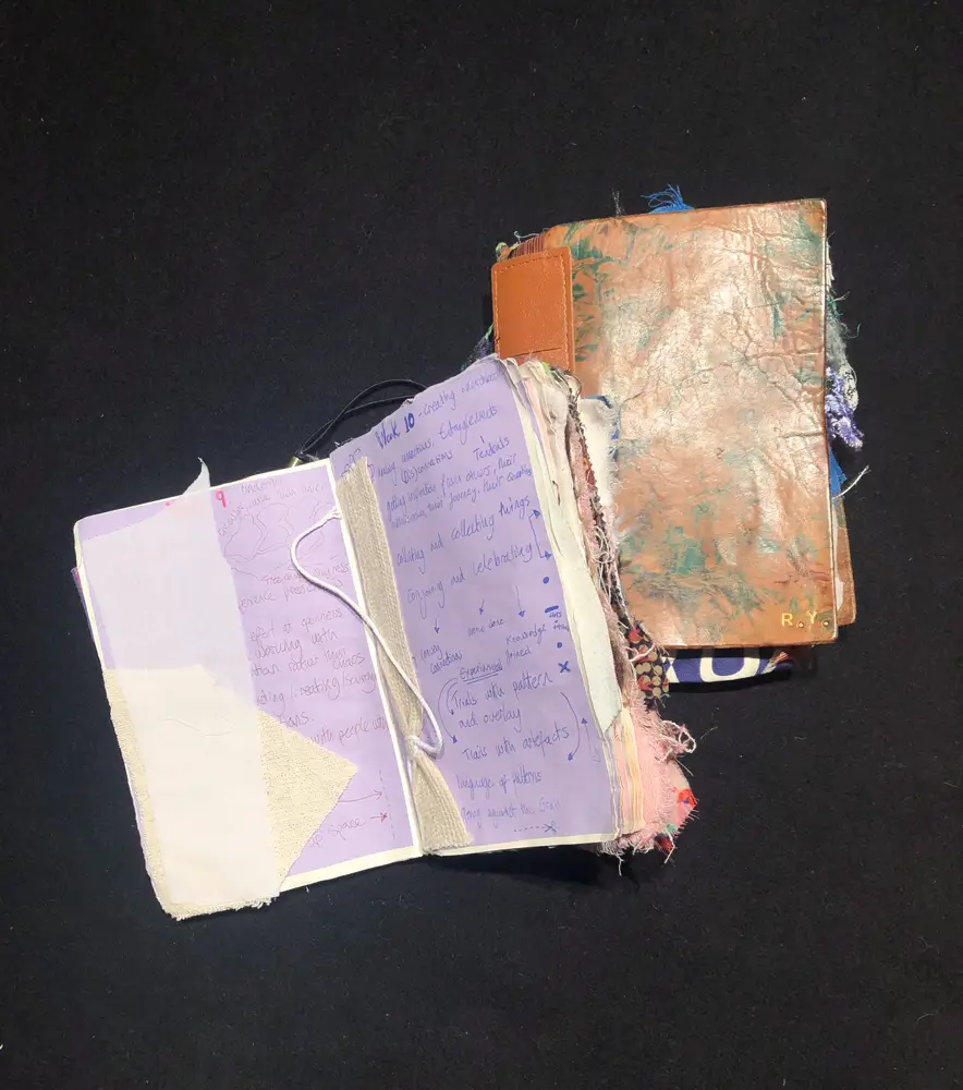 two notebooks with material attached